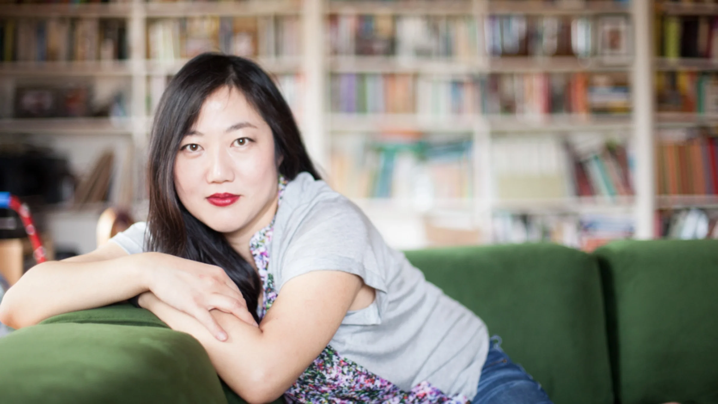 Christine H. Lee is pictured sitting on a green sofa.