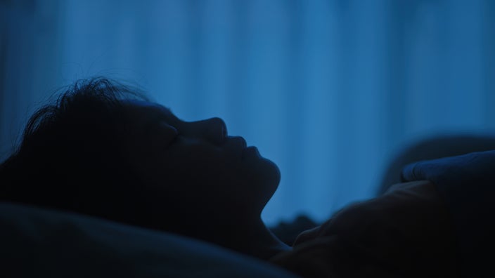 A silhouette of a person with insomnia.