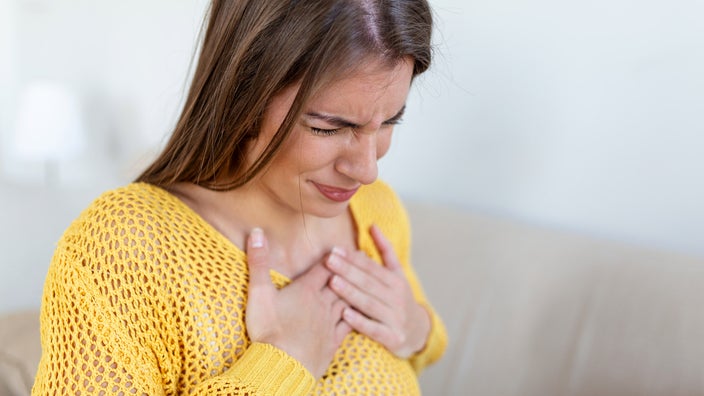 A woman holding her hands to her chest.