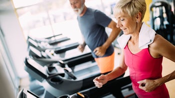 Health: Health insurance: senior couple at gym on tredmills-1171659624