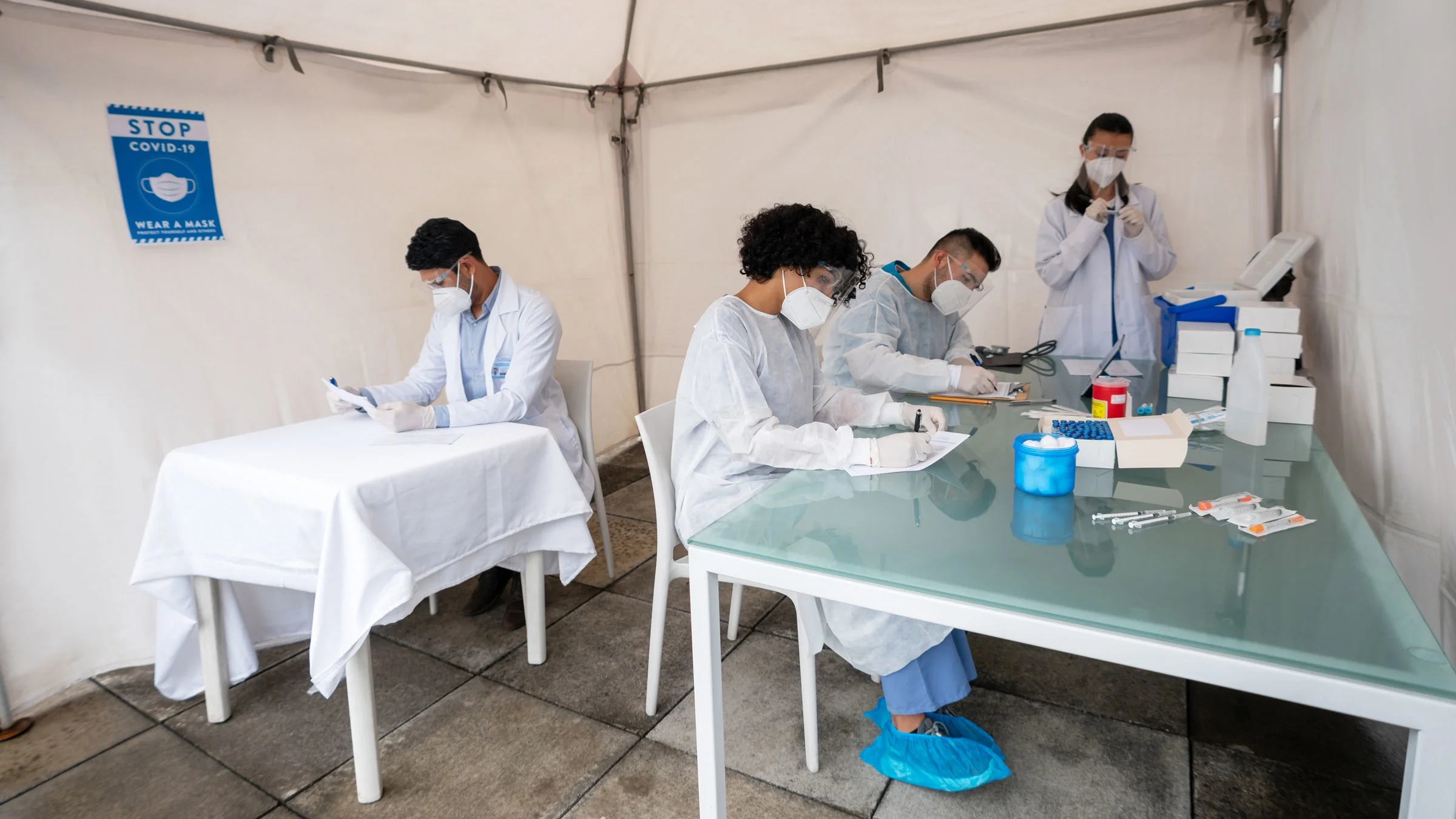 Healthcare workers working at a COVID-19 vaccine on-site tent.