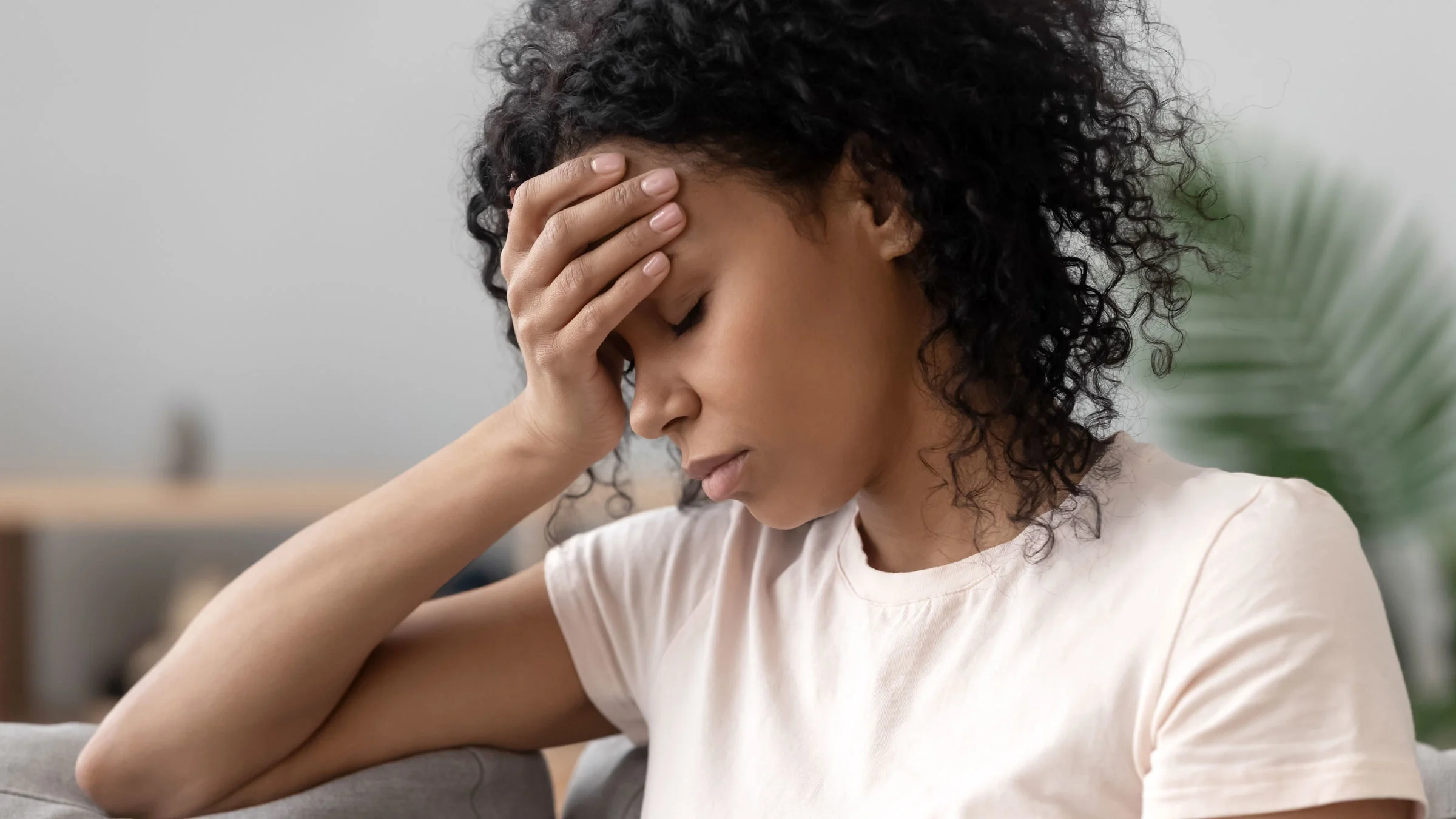 Woman sitting on couch looking stressed
