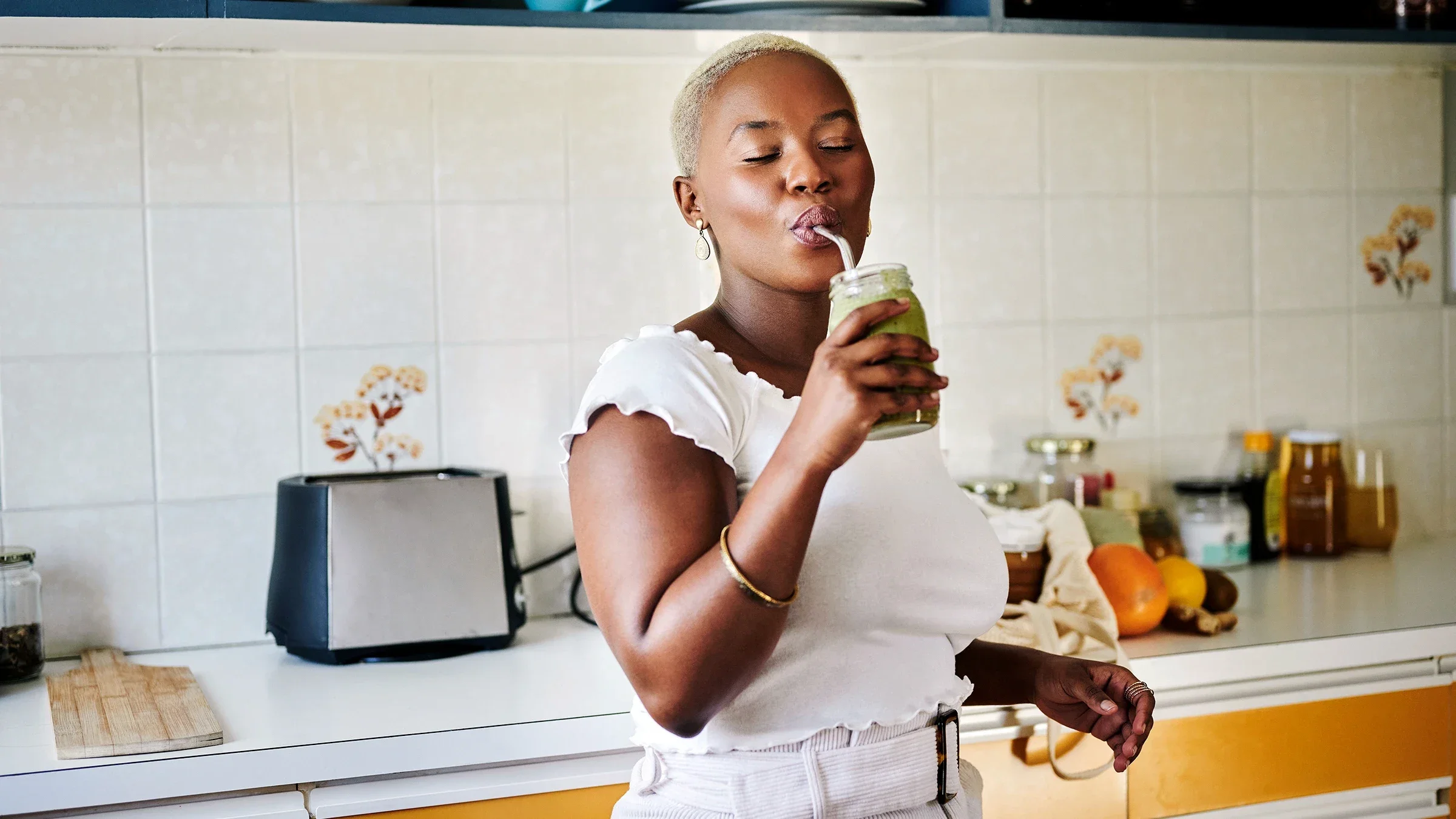 A woman drinks a smoothie with a straw.
mapodile/E+ via Getty Images