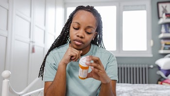 adhd: woman reading Rx bottle 1466975060