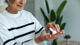 A woman shakes medicine into her hand from a pill bottle.
g-stockstudio/iStock via Getty Images Plus