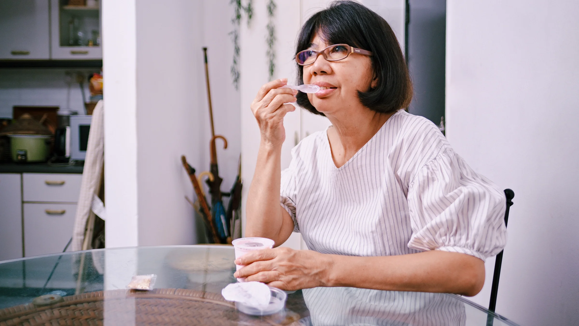 Woman eating yogurt at home.