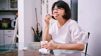 Gut health: woman eating yogurt 1482254837