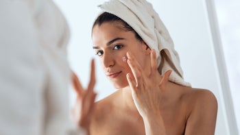 Health: Acne: woman applying zit cream GettyImages-1328284623