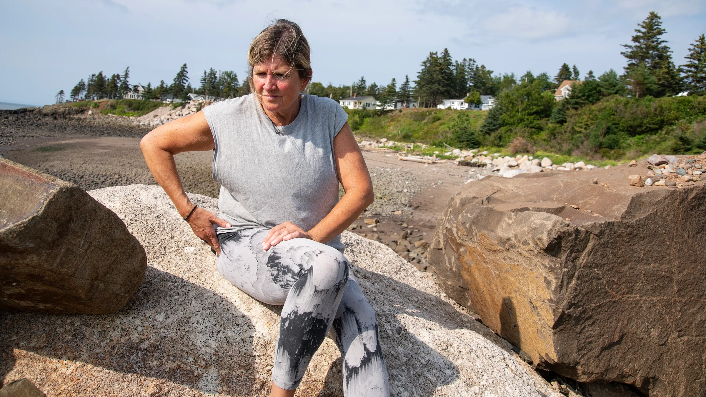 A woman is holding her hip in pain.