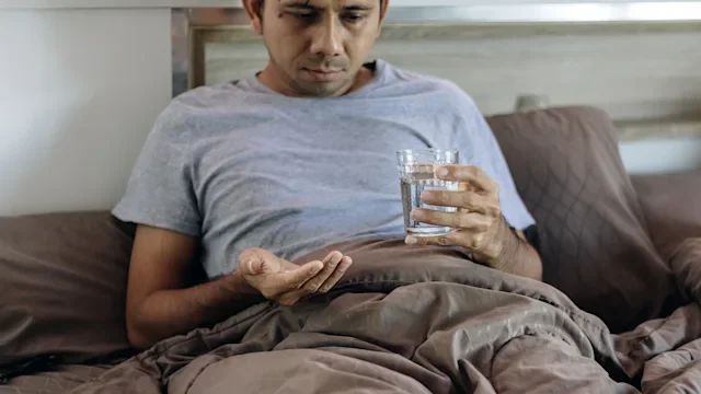gabapentin: man taking medication in bed 1251325761