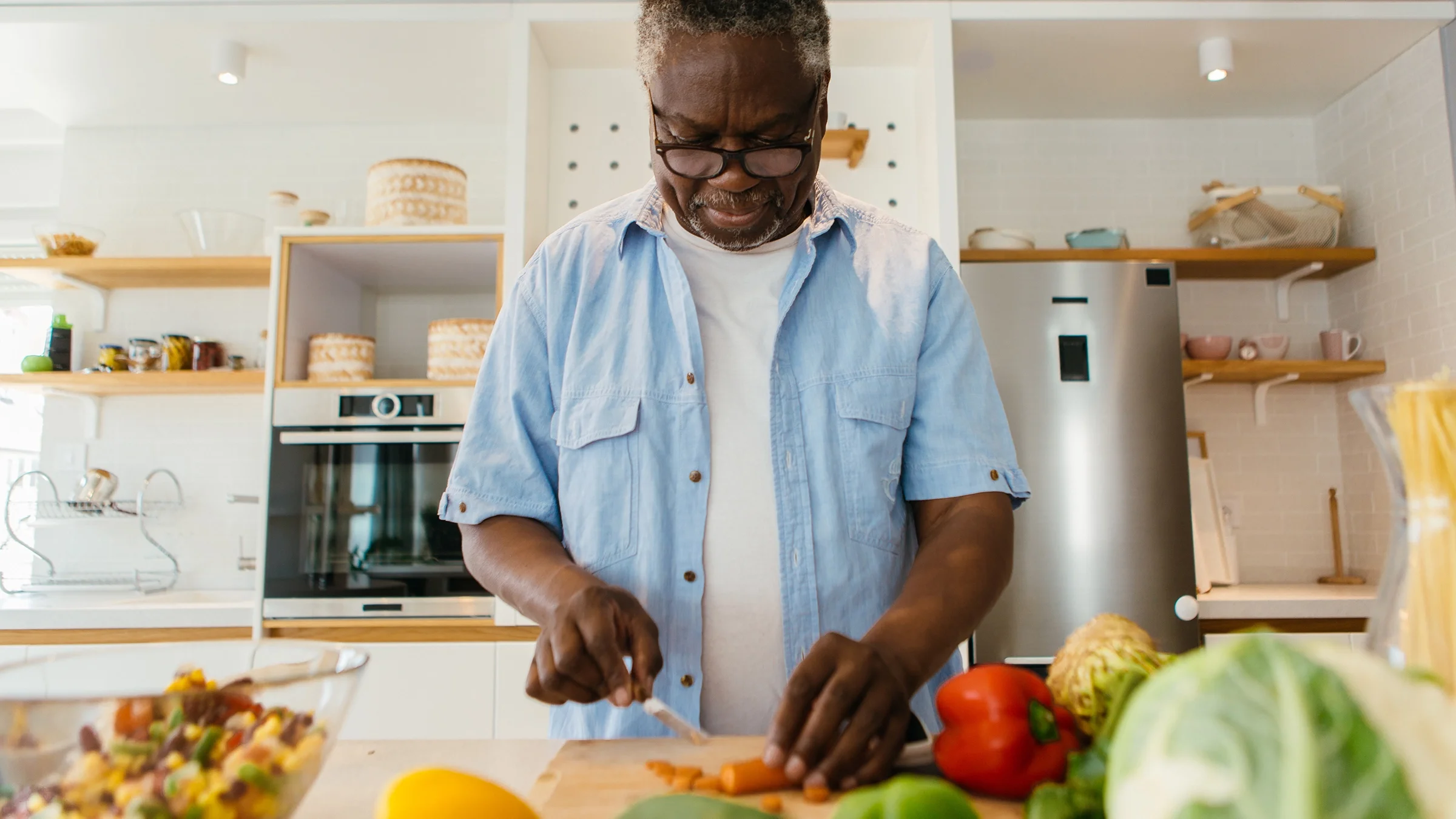 Man cutting carrots in the kitchen at home