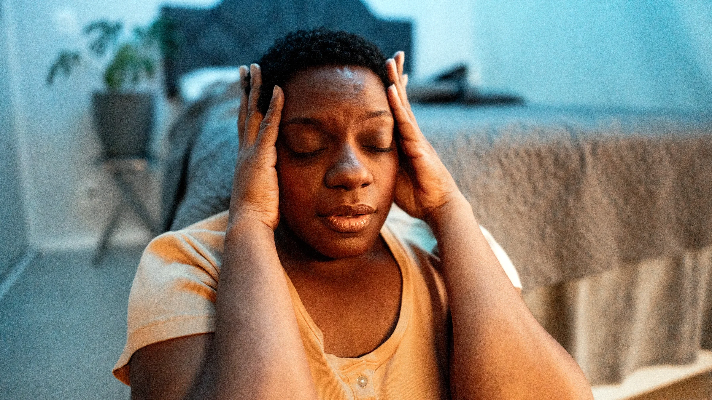 Woman feeling emotional while sitting on the floor in the bedroom.