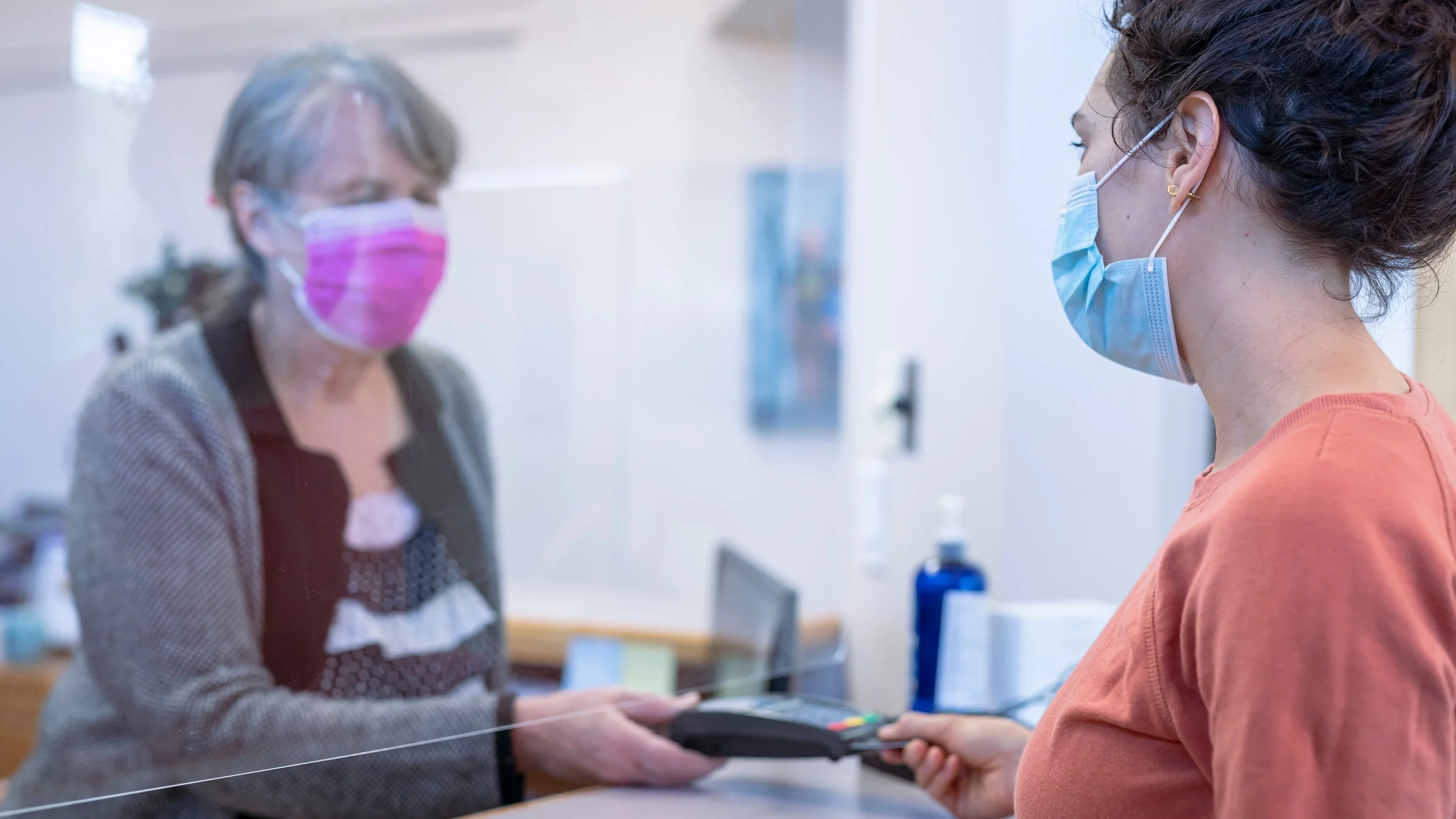 An older adult paying for services at a clinic.