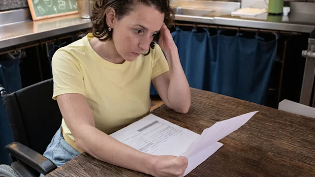 Health: Medical debt: woman reading financial bill 1313000099