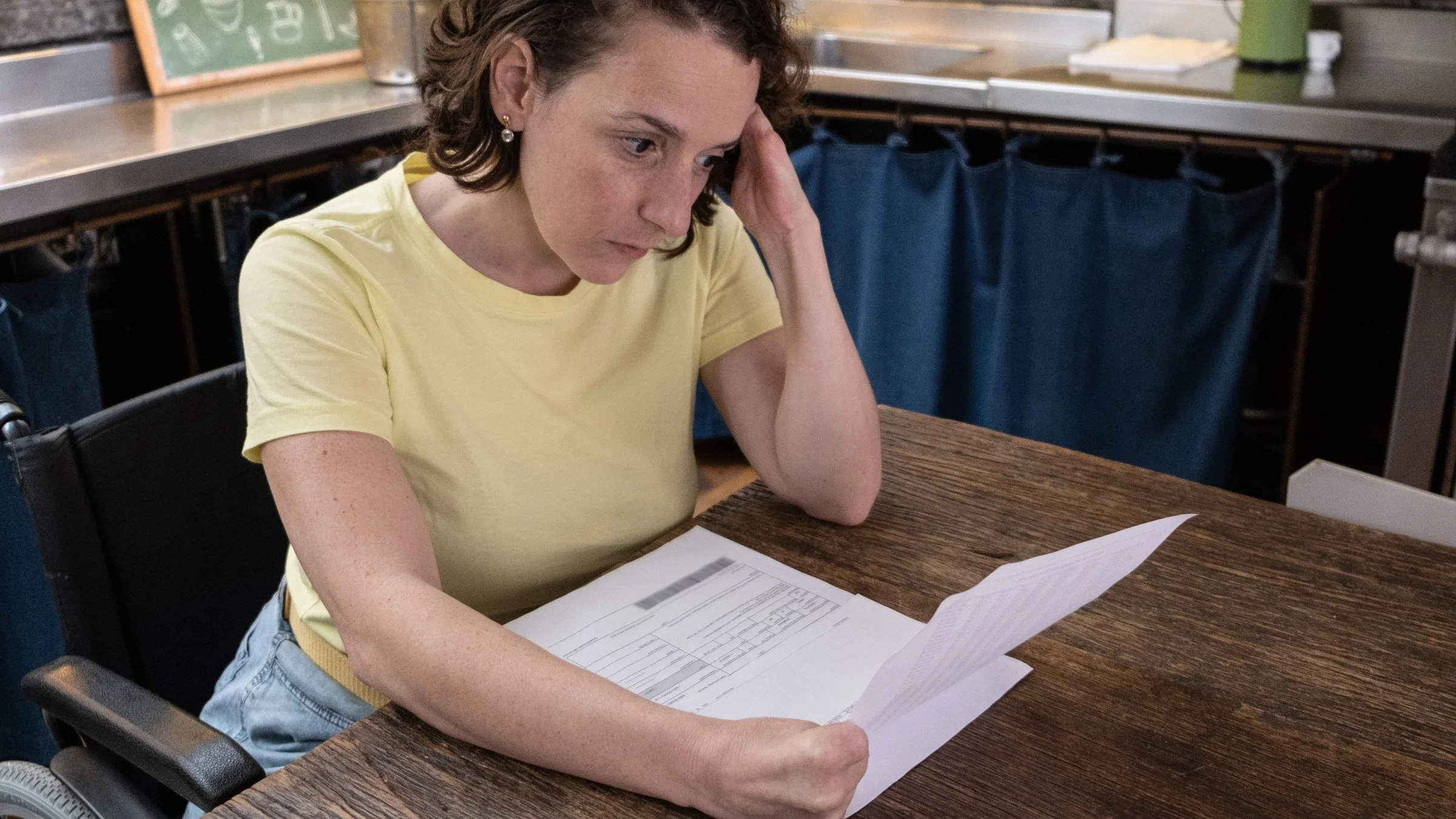 Disabled woman looking for financial bills at home.