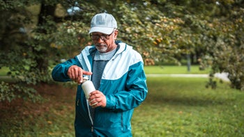 Diet and nutrition: senior man drinking out of reusable bottle 2158791992