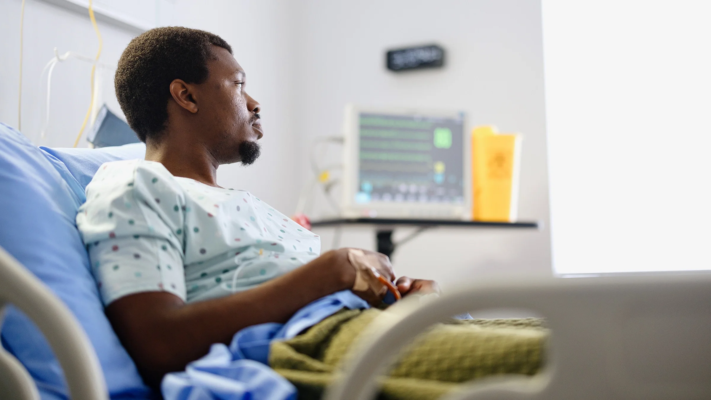 A man lies in a hospital bed.