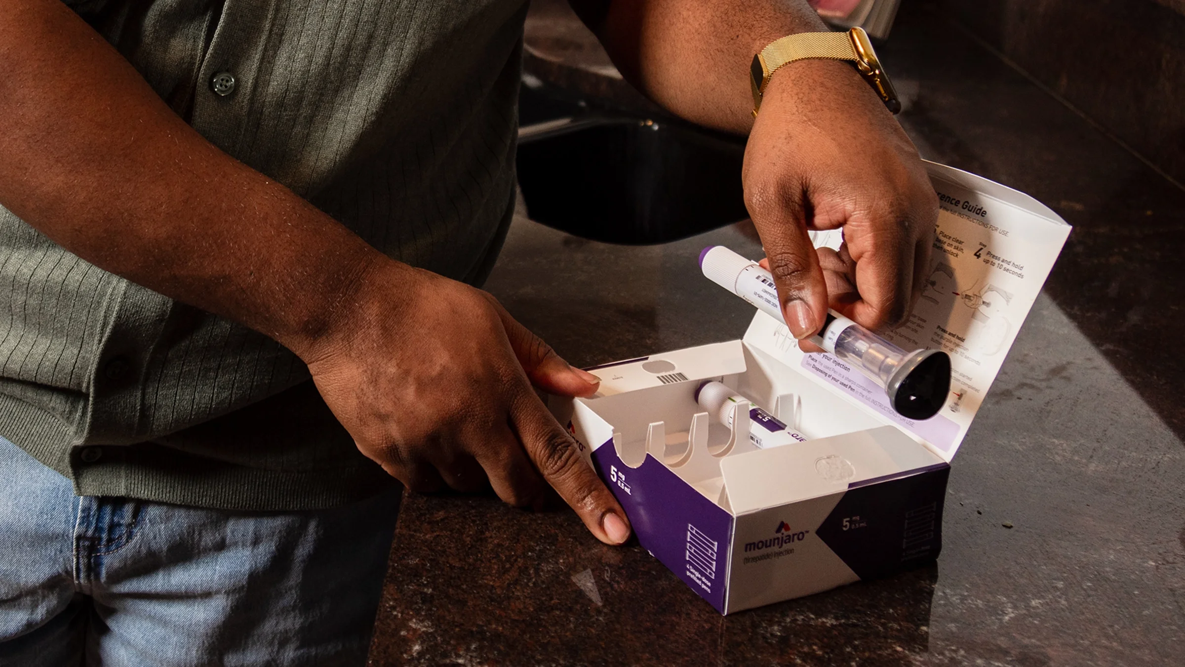 A person takes a Mounjaro injection pen out of the box.