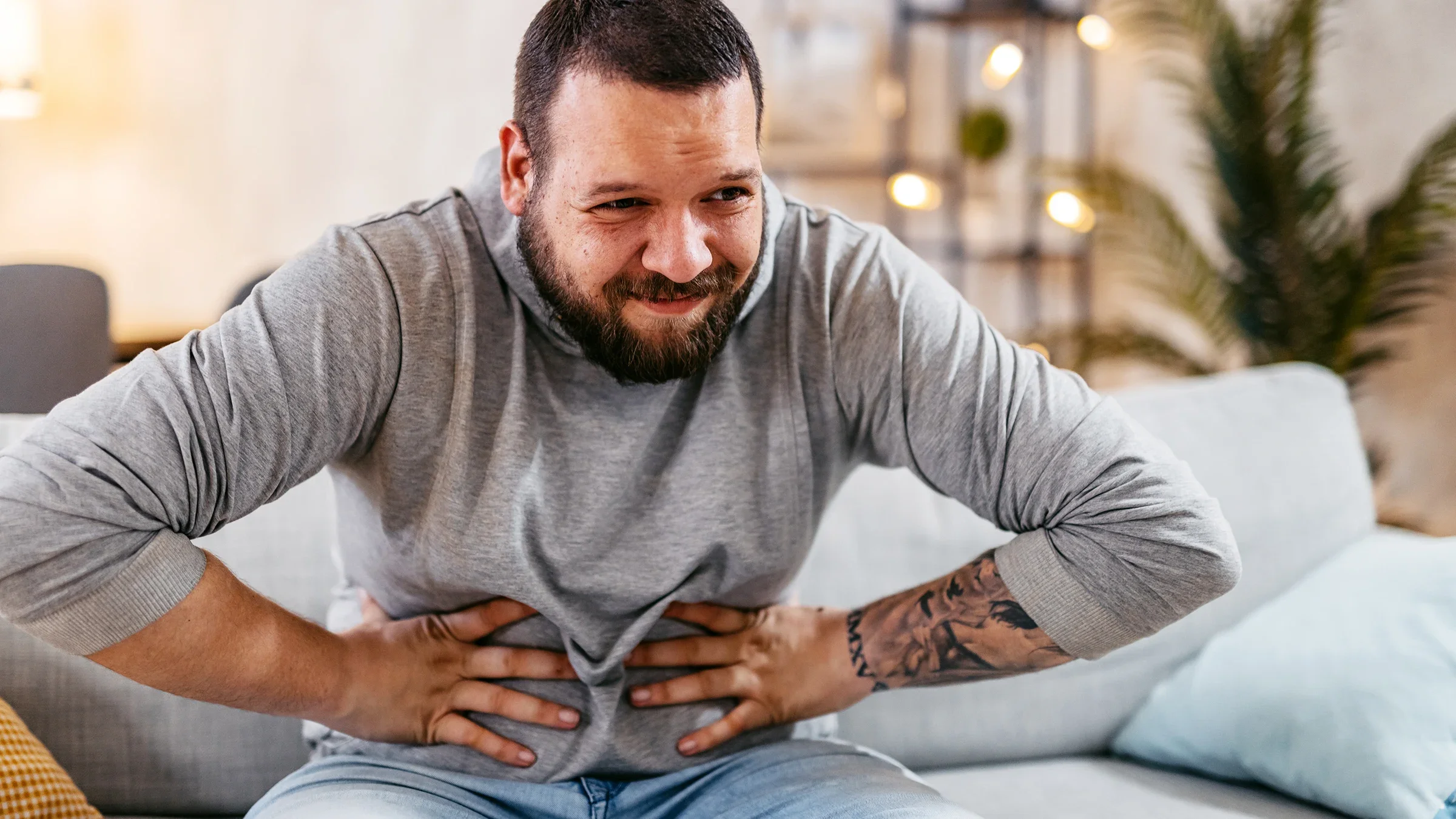 A man sits at home with stomach pain. Diarrhea is one of the side effects of Ozempic, a medication used to treat Type 2 diabetes. 
urbazon/E+ via Getty Images