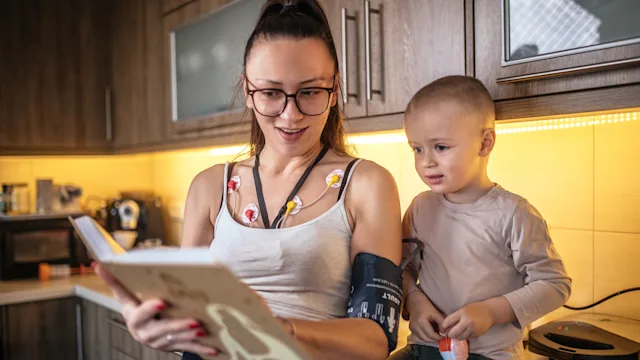 Heart: Cardiac monitoring insurance: parent with holter monitor reading book 1471663190