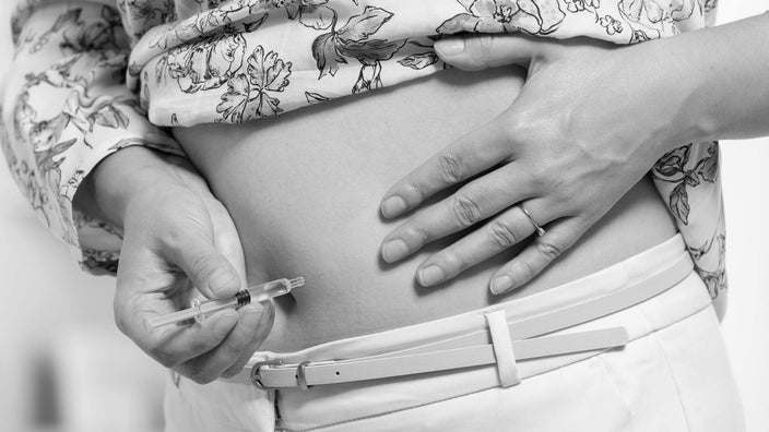 Black and white close-up of a person injecting insulin.