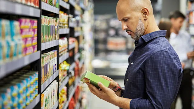 diet nutrition: man reading label in grocery store 1343543856
