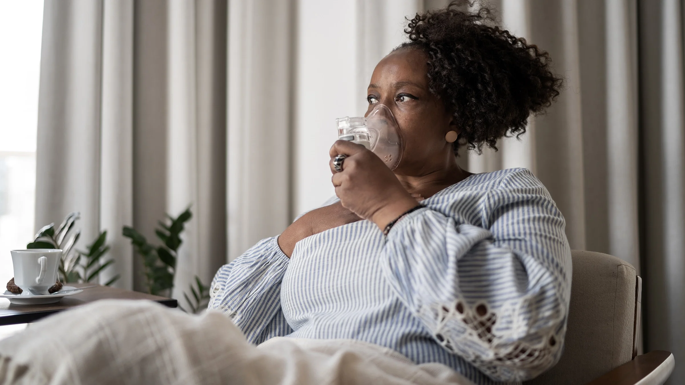 Woman using an inhalation mask at home