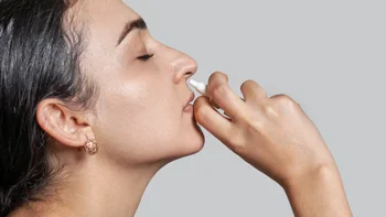 Allergies: woman using nasal spray 1348933795