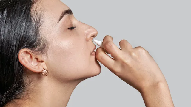 Allergies: woman using nasal spray 1348933795