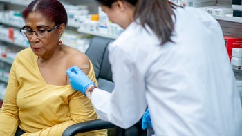 Vaccines: Pharmacy technician: bandaid after vaccine pharmacy 1279220076