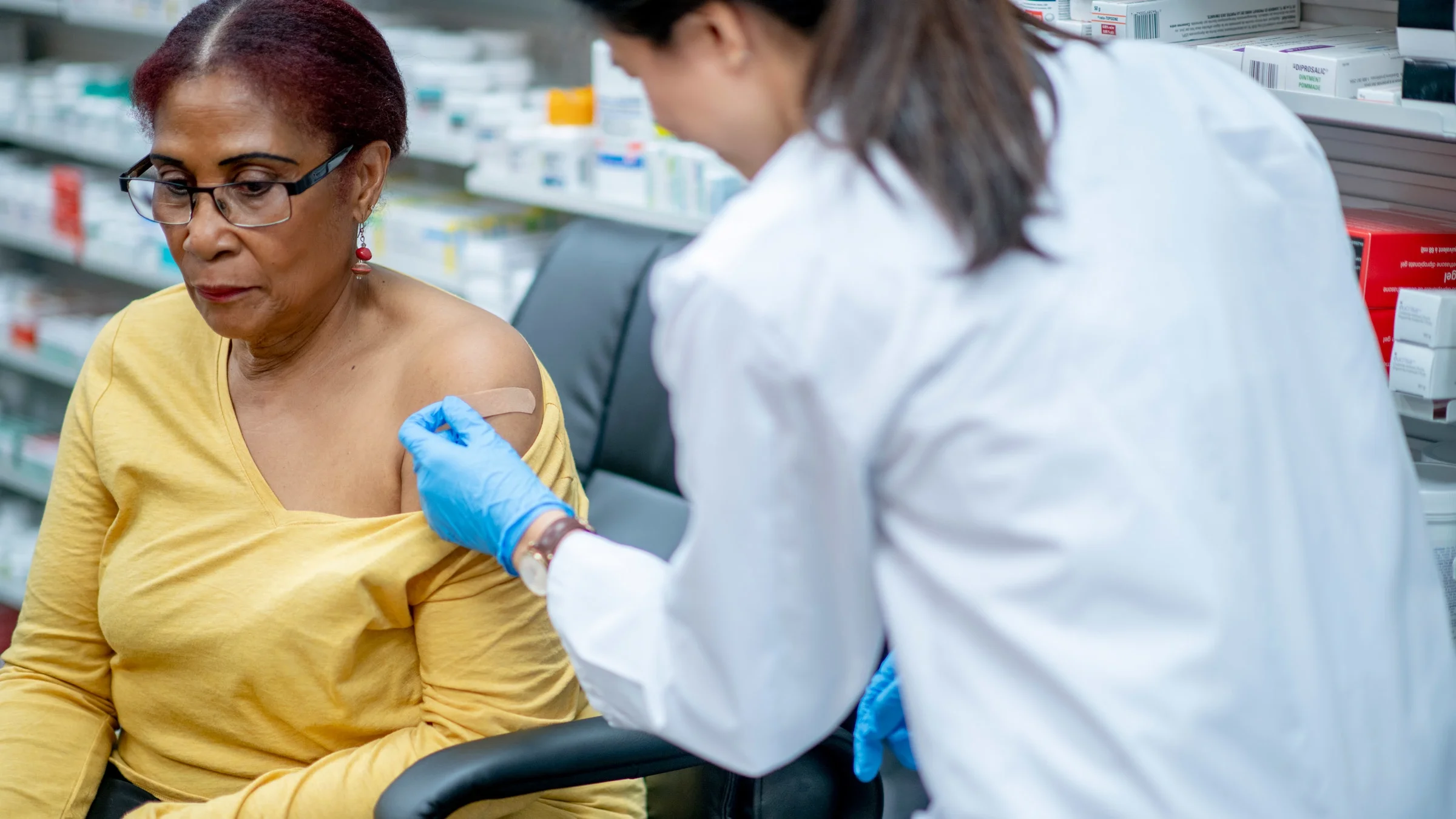 A person receiving a vaccine inside a pharmacy.