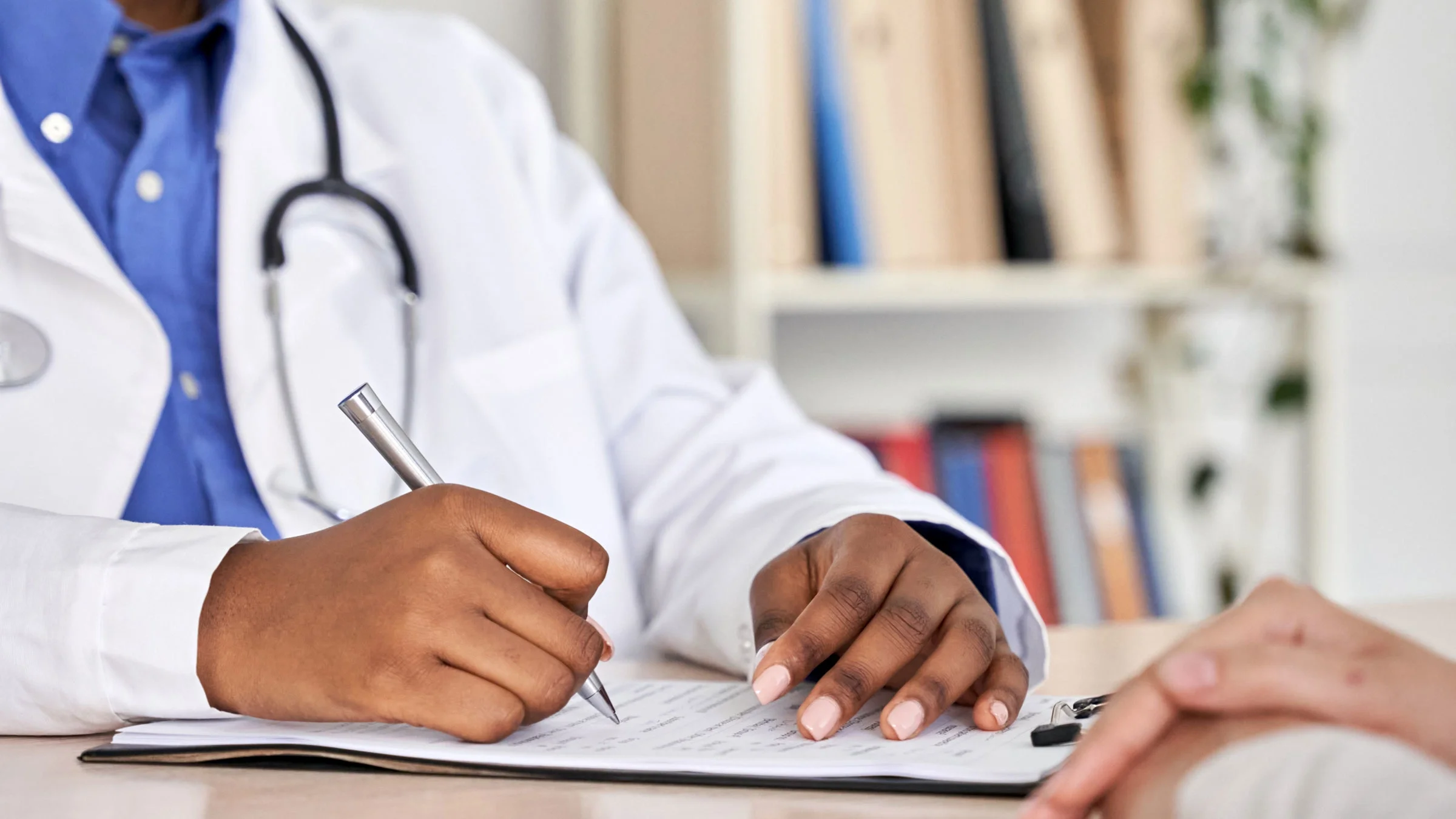 A doctor fills out a form with a patient.