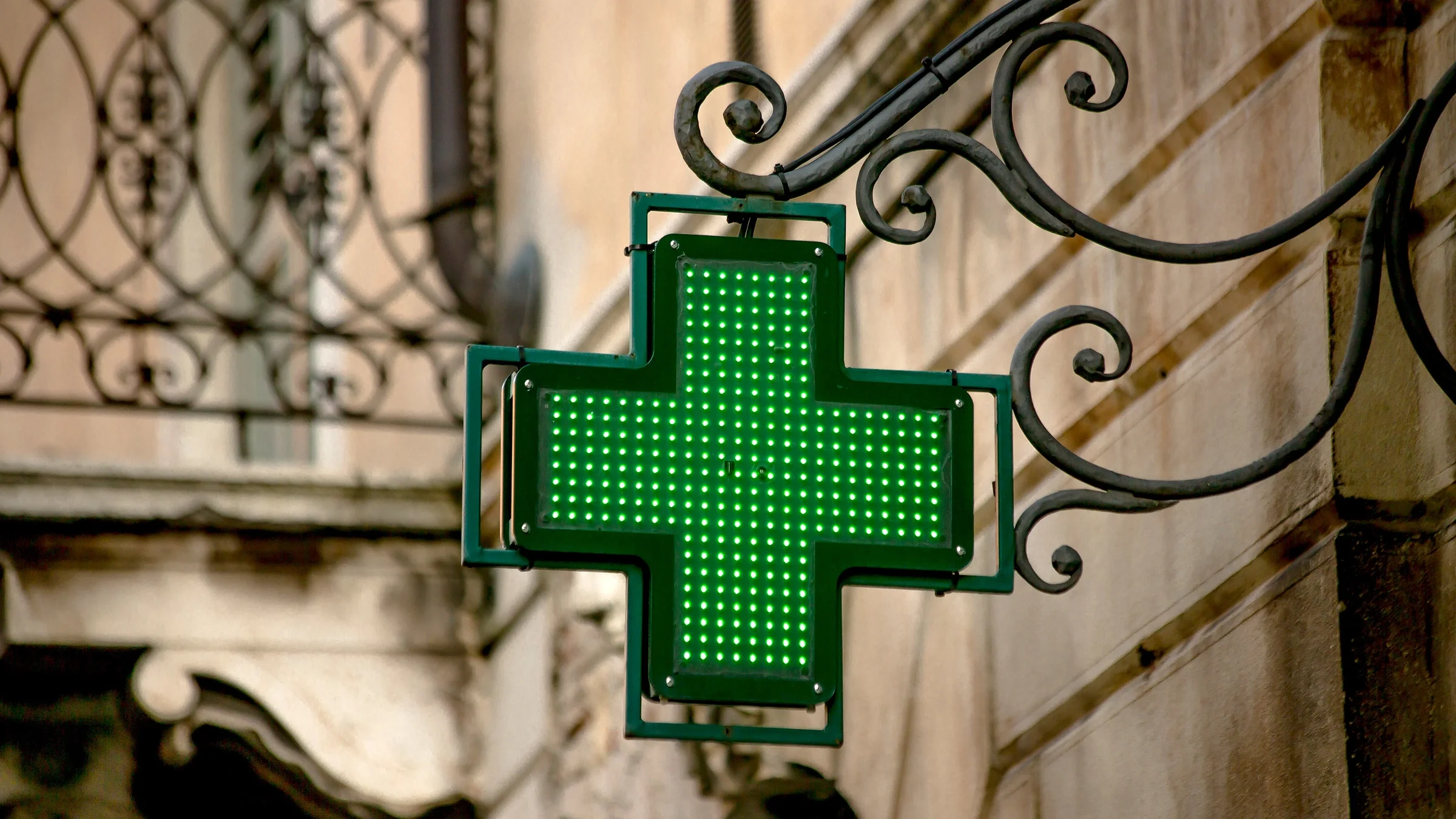 A green cross sign for a store.
