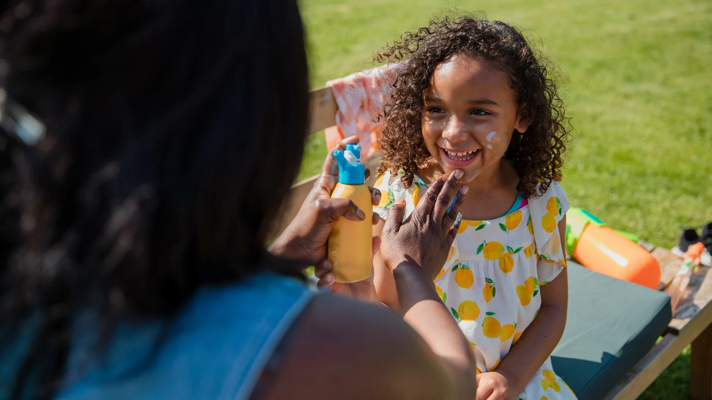 Dermatology: mom applying sunscreen on daughters face-1334431945