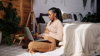Black health: depression: woman using laptop in her bedroom 1392127008