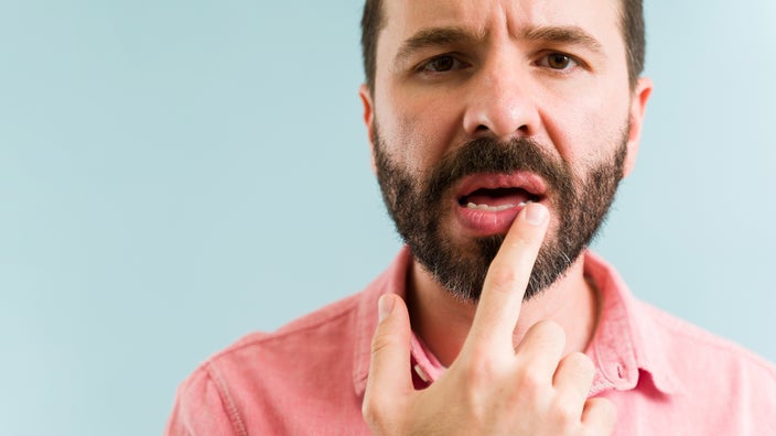 A person is touching their lips.