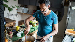 A man stirs ingredients in a pot as he cooks in his kitchen at home.
FG Trade/E+ via Getty Images