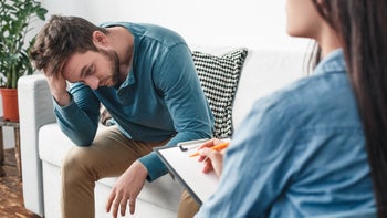 Naltrexone: substance use: therapy: exhaused sad man therapist office 1145533893