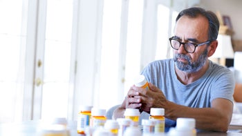 Health: Actos: man reading Rx bottle 955764626