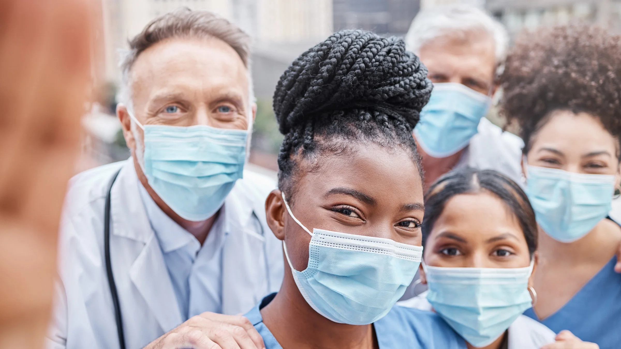 A group of healthcare professional colleagues taking a selfie.
