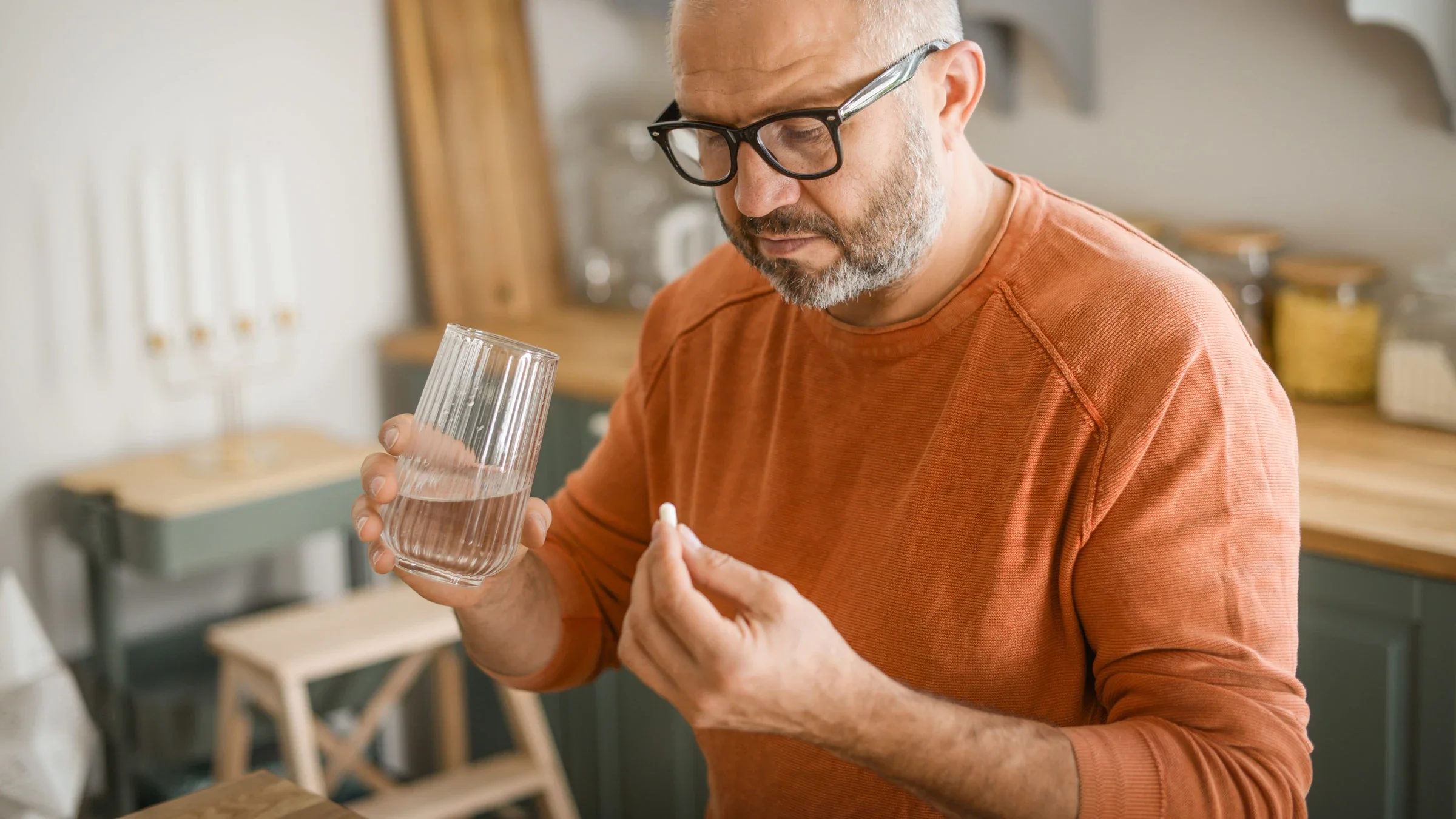abilify: medication: pills: man taking medication holding glass of water 1354039178