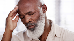 A man grimaces and touches his forehead upon feeling dizzy.
LaylaBird/E+ via Getty Images