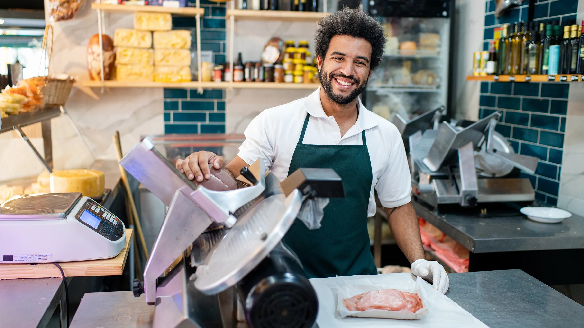 Butcher slicing deli meat with electric slicer