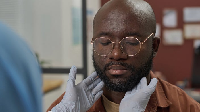 Close-up medical professional examining patient's lymph nodes.