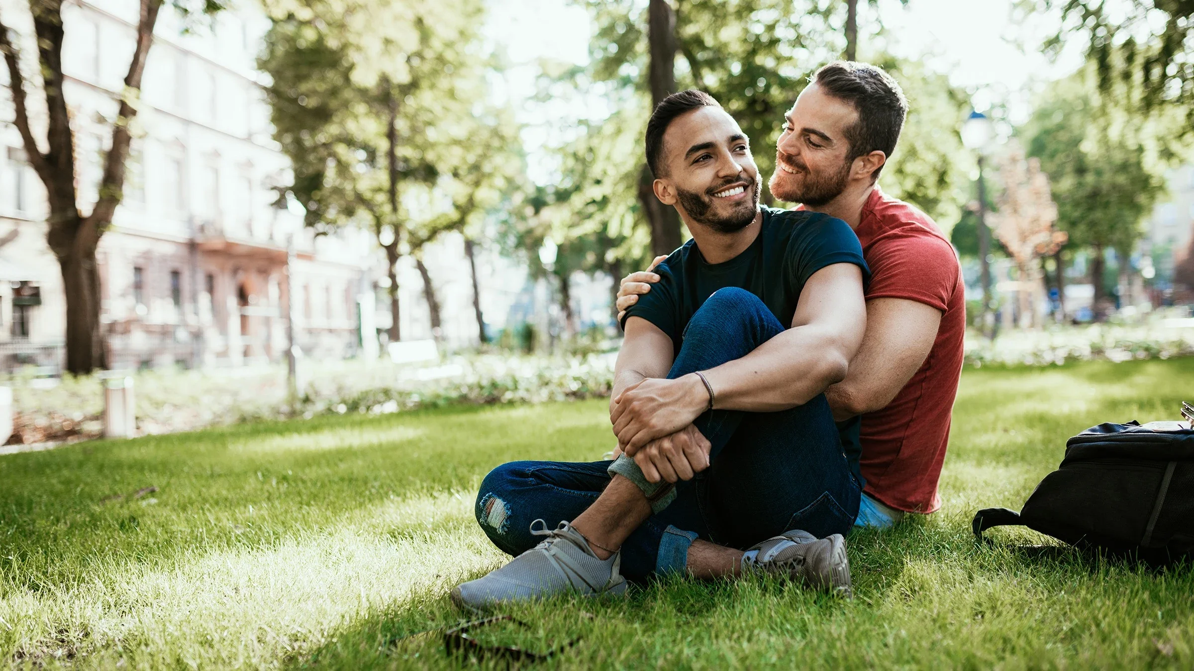 Portrait of an attractive queer couple cuddled up together in the park.
Drazen_/E+ via Getty Images