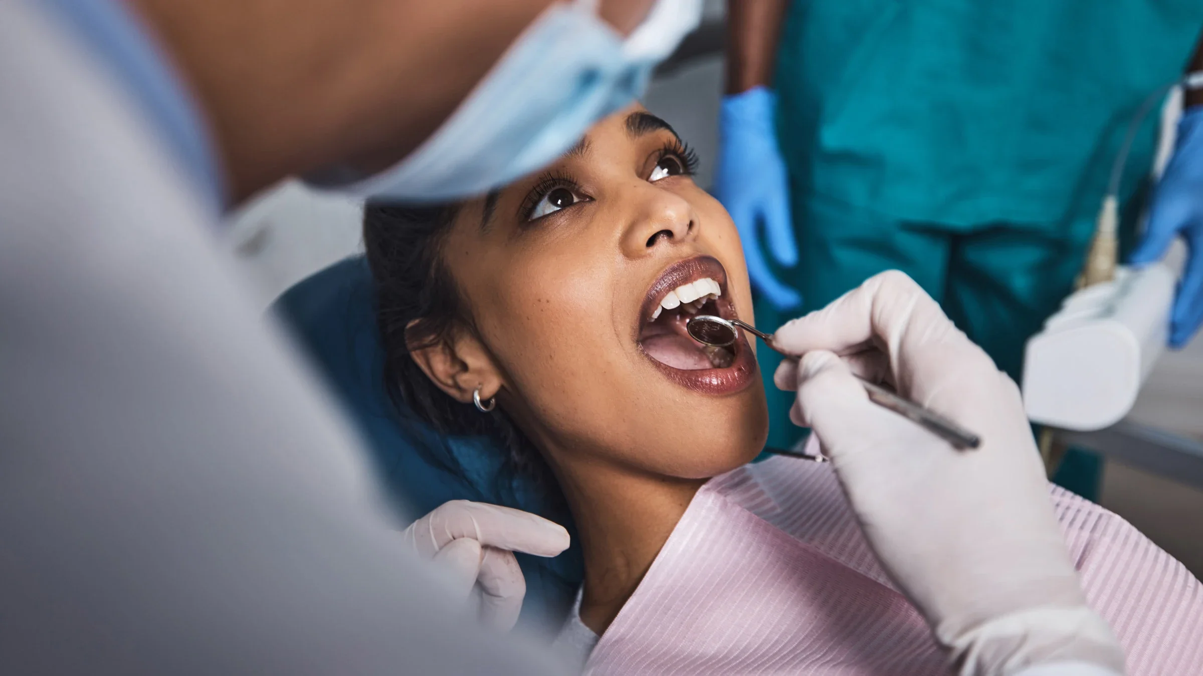 A person opening their mouth for a healthcare professional to examine.
PeopleImages/iStock via Getty Images 