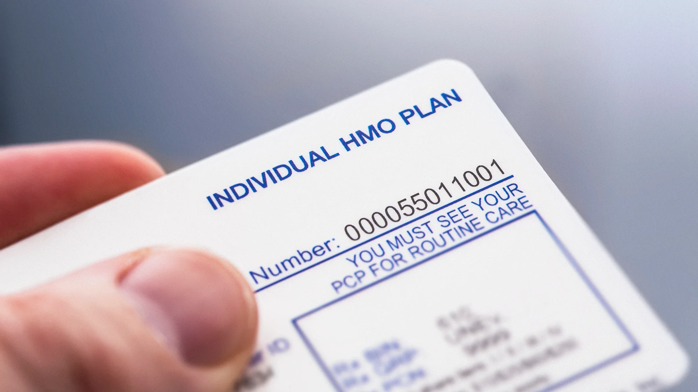 Close-up of a person’s hand holding an HMO insurance card.
LPETTET/iStock via Getty Images