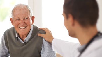 Health: Medicare: senior man smiling with doctor 499783401