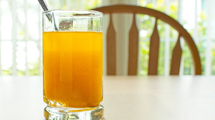 A glass of water mixed with fiber powder is on a table.