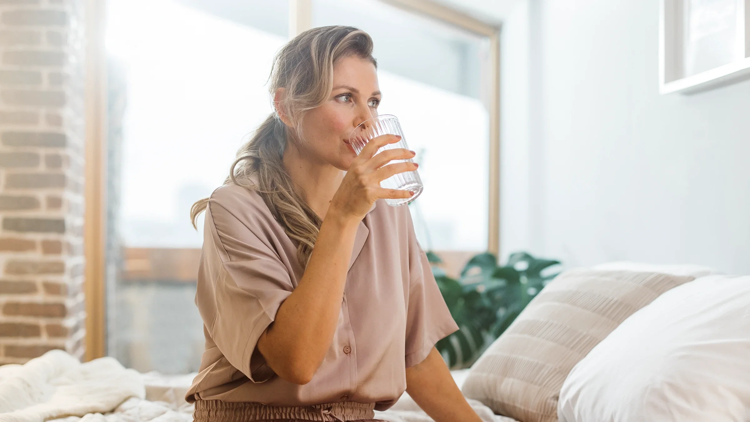 A woman takes her medication in the morning.